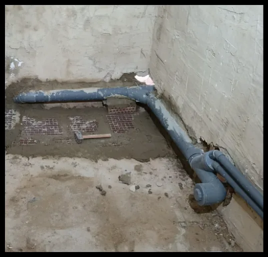 Desagüe de PVC gris embebido en el suelo de un baño en obra.