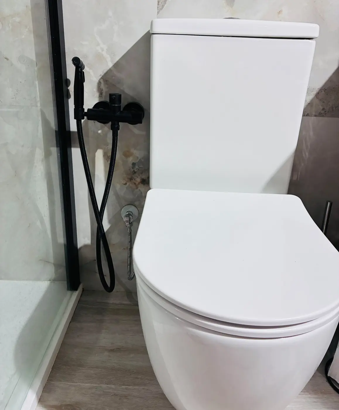Inodoro blanco con pulverizador higiénico negro mate.